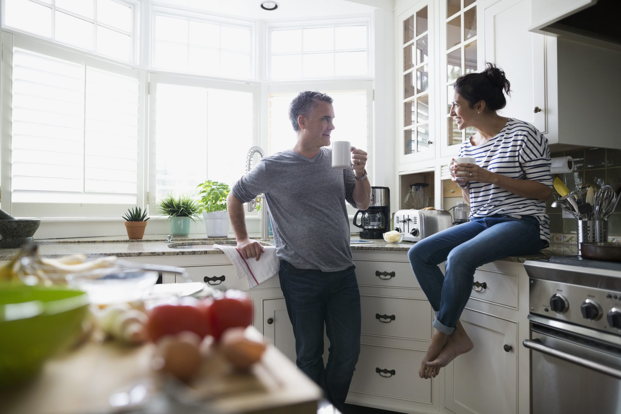 man and woman drinking homemade coffee in the kitchen